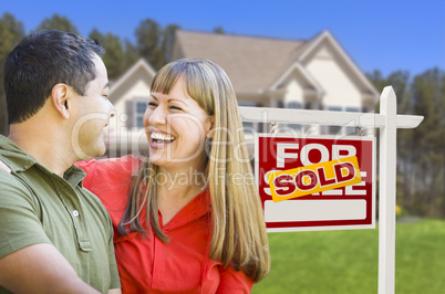 Couple in Front of Sold Real Estate Sign and House