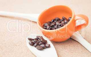 Coffee bean in ceramic cup and wood spoon