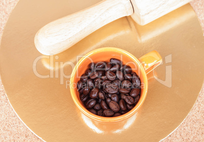 Roasted coffee beans in a cup on the table