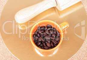 Roasted coffee beans in a cup on the table