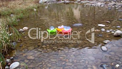 Colored paper boats floating on a small lake