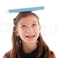 Mädchen balanciert ein Buch auf dem Kopf