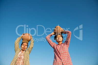 Asian traditional farmers carrying pot on head