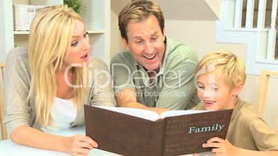 Young Boy and Parents Looking Through Family Photos