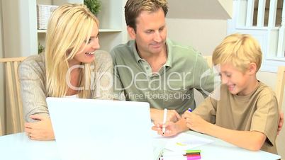 Young Boy Using Laptop and Crayons for Project