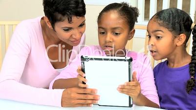 Ethnic Mother and Daughters Using Wireless Tablet