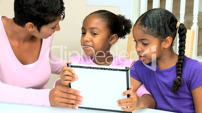 Ethnic Mother and Daughters Using Wireless Tablet