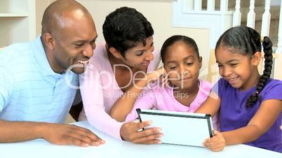 Young Parents Watching Children Using Wireless Tablet