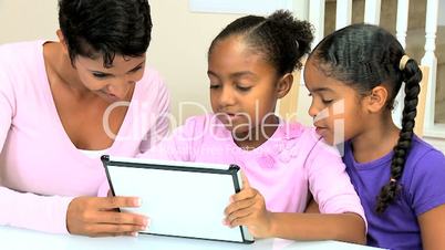 Ethnic Mother and Daughters Using Wireless Tablet