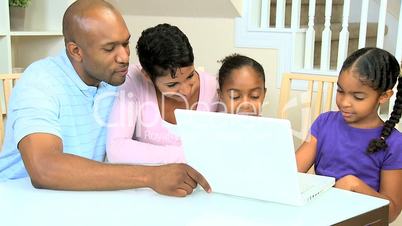 Ethnic Parents Watching Daughters Using Laptop