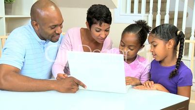 Proud Ethnic Parents Watching Daughters Using Laptop