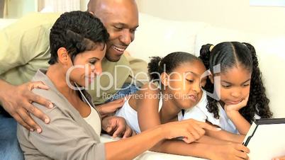 Young Parents Watching Children Using Wireless Tablet
