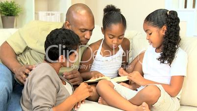 Little Ethnic Girl Reading a Book to her Family