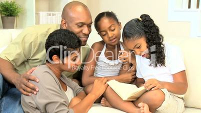 Young Ethnic Child Reading Aloud to Family