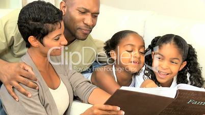 Young Ethnic Family Enjoying Photograph Album