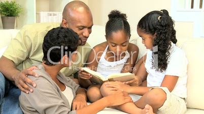 Little Ethnic Girl Reading a Book to her Family