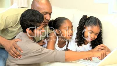 Ethnic Parents Watching Daughters Using Laptop