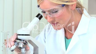 Female Medical Researcher Using Microscope