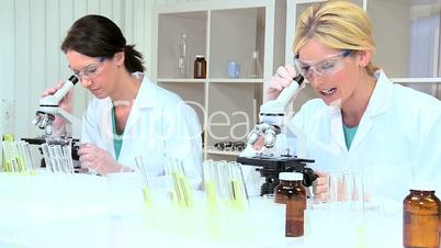 Female Medical Researchers Using Microscopes