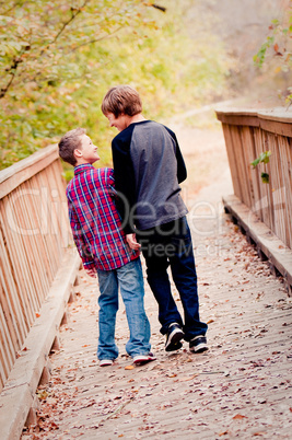 Two boys looking at each other on a bridge