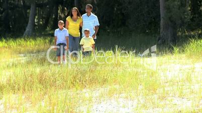 Young Ethnic Family Walking on Parkland