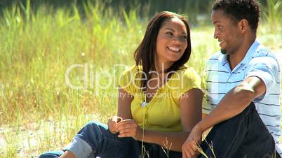 Young Ethnic Couple Sitting in Park
