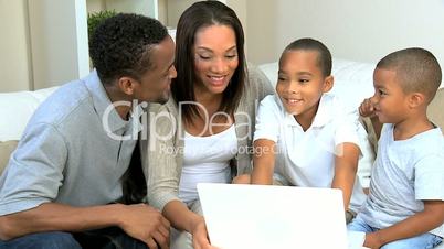 Ethnic Parents Watching Young Sons Using Laptop