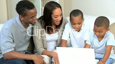 Ethnic Parents Watching Young Sons Using Laptop