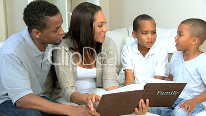 Young Ethnic Family Looking at Photograph Album