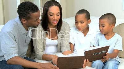 Young Ethnic Family Looking at Photograph Album