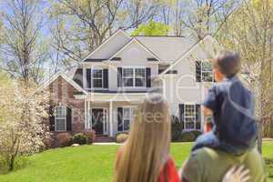 Mixed Race Young Family Looking At Beautiful Home