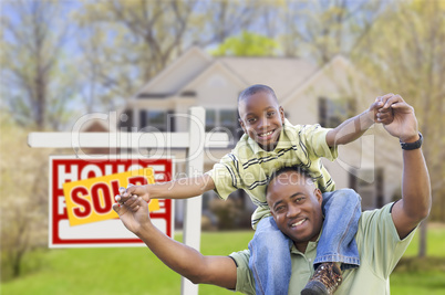 Father and Son In Front of Real Estate Sign and Home