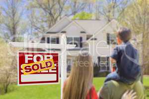 Family Facing Sold For Sale Real Estate Sign and House