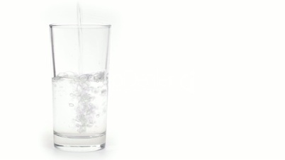 Water pours in glass with ice isolated on white background.