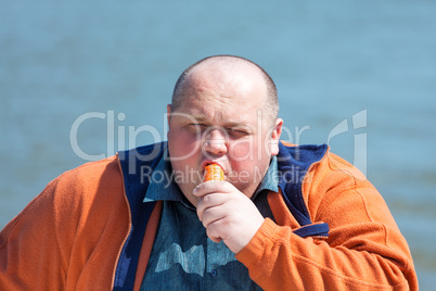 Fat man eating a carrot