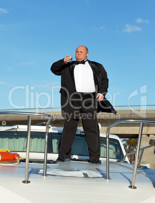 Fat man in tuxedo with glass wine