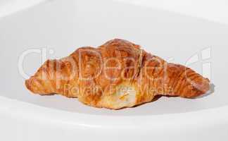 Fresh and tasty croissant on white