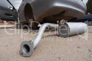 The new muffler against the dirty car