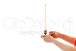 Die junge Frau hält eine Kerze in den Händen
