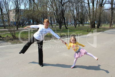 Mother with the daughter which dance in the city