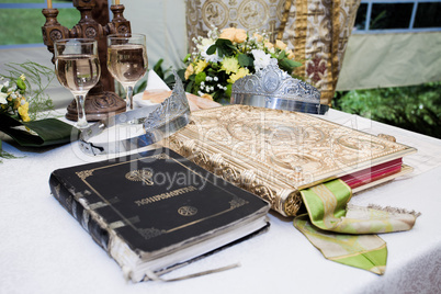 Wedding crowns, bible and wine glasses prepared for ceremony