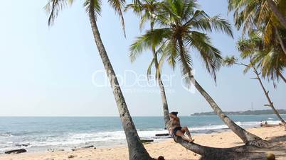 Woman lying on palm tree.