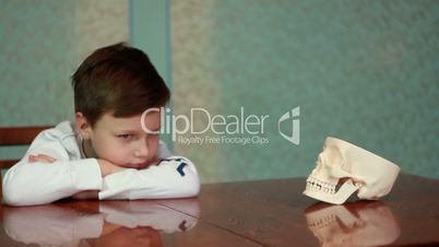 Boy plays with skull