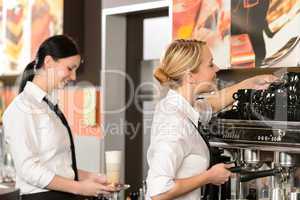 Two waitresses serving coffee with machine