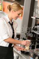 Attractive waitress making coffee with machine