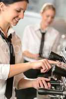 Smiling women waitress preparing coffee machine