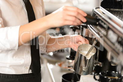 Barista steaming milk for hot cappuccino