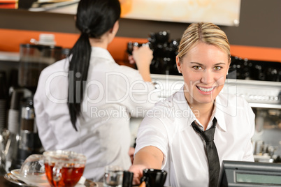Young waitress cashier giving coffee in cafe