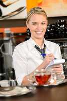 Smiling waitress taking order in coffee house