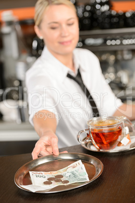 Attractive waitress taking tip in bar CZK